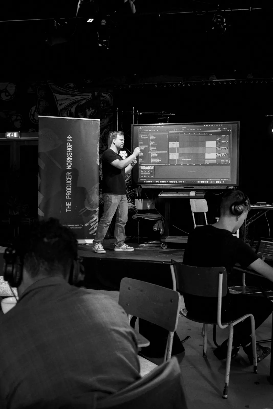 Mark Wagenaar legt muziekproductie uit op een groot scherm